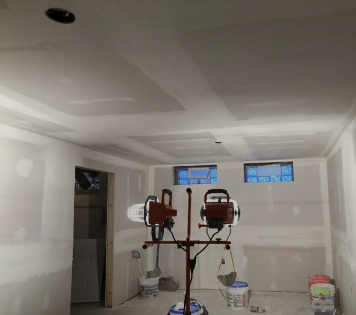 Finished basement build-out with smooth taped ceilings, crisp corner bead and glass block windows, ready for primer
